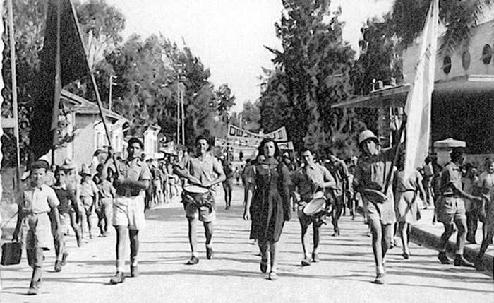 תהלוכת ה-1 במאי בפ"ת. נסים נושא את הדגל האדום, 1946 תמונה