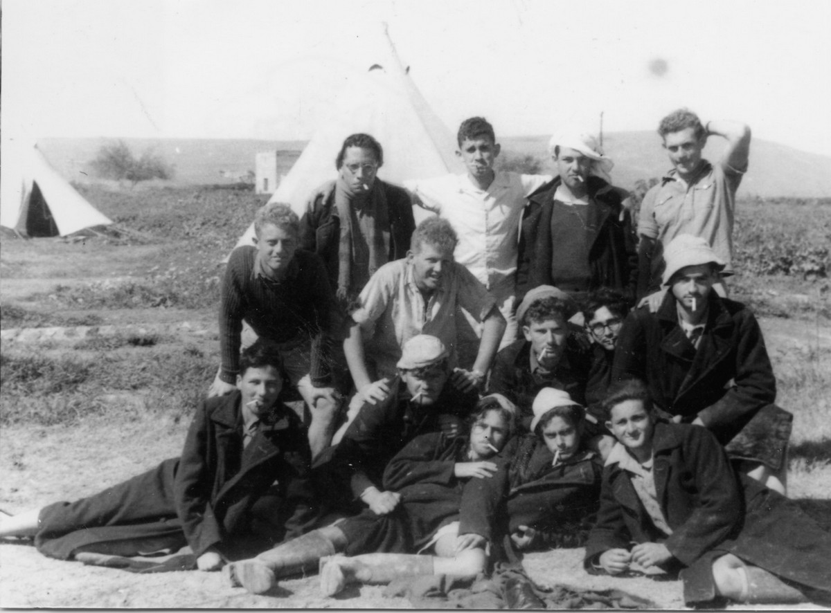 פלוגה ד', הכשרת מעוז חיים. תיאור התמונה: המעשנים ב- "טיול דה לה פרטיזן", מופיעים בתמונה: ישראל זק, דני רוזוליו, ניסים ניסמוב, אורי ספקטור, אפריים בילו, מולה ג'רבן, זכריה טרבס, משה כהן ואחרים. נתקבל מ: יעקב פלד תמונה